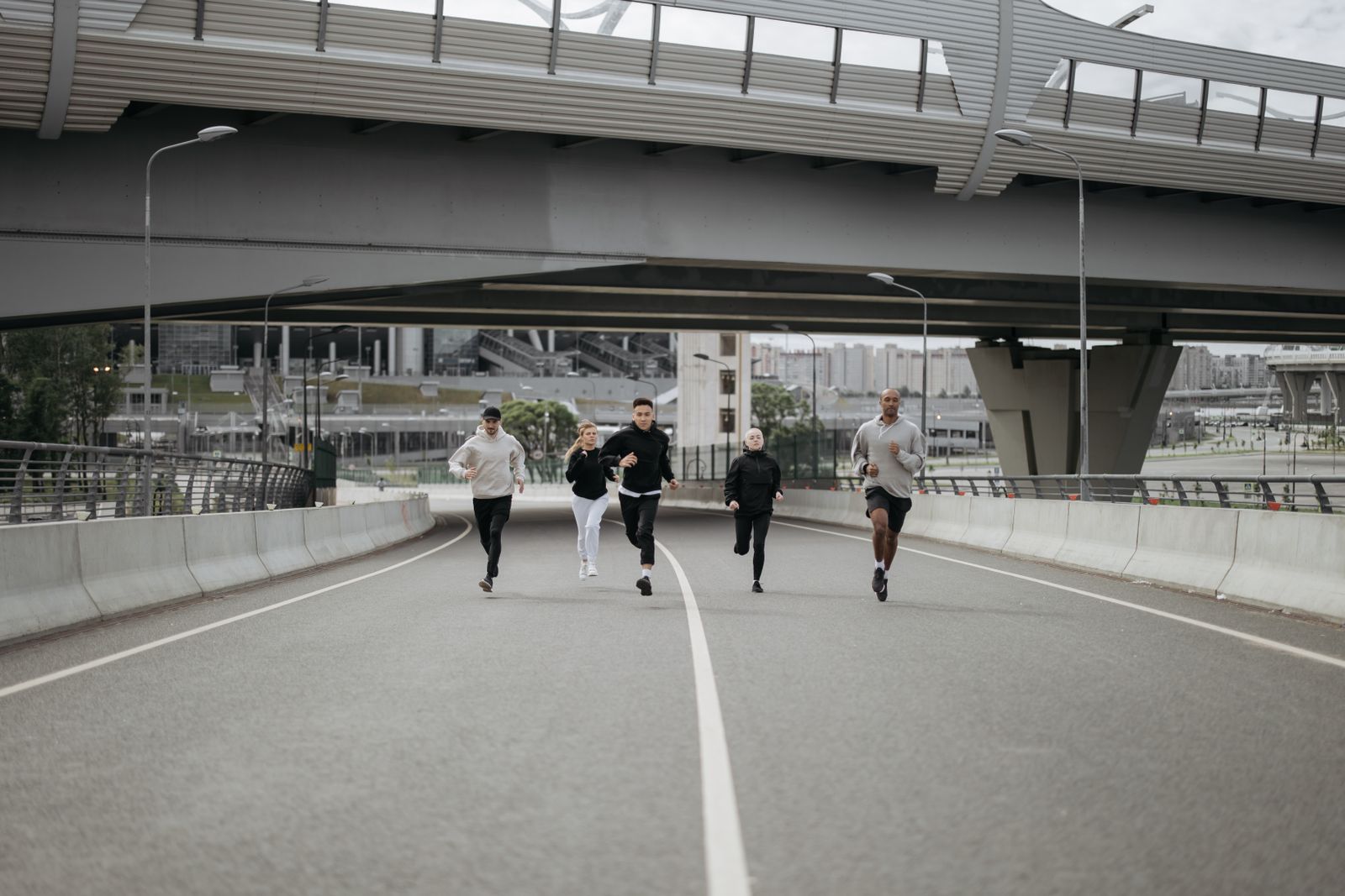 Un grupo de corredores entrena junto por una carretera urbana.