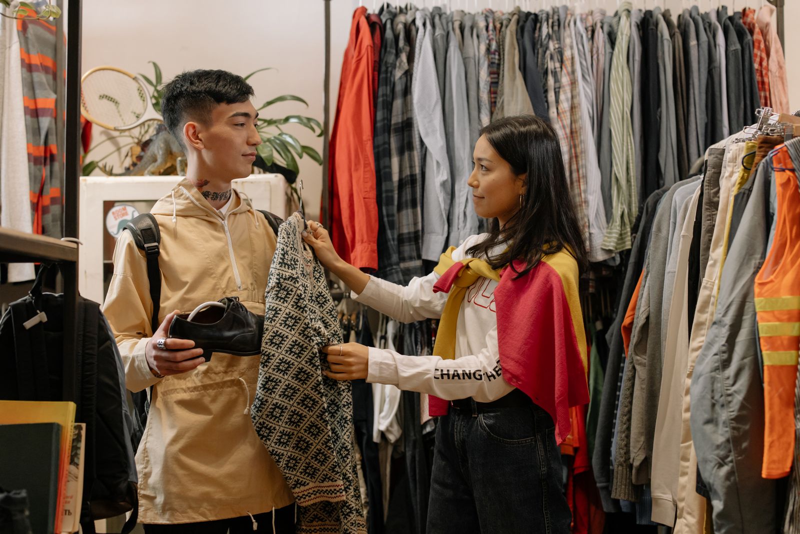 Una pareja compara prendas en una tienda de ropa.